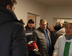 Mehrere Personen und die Seelsorgerin in einem neuen Haus.