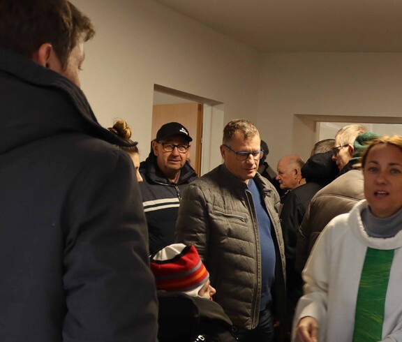 Mehrere Personen und die Seelsorgerin in einem neuen Haus.
