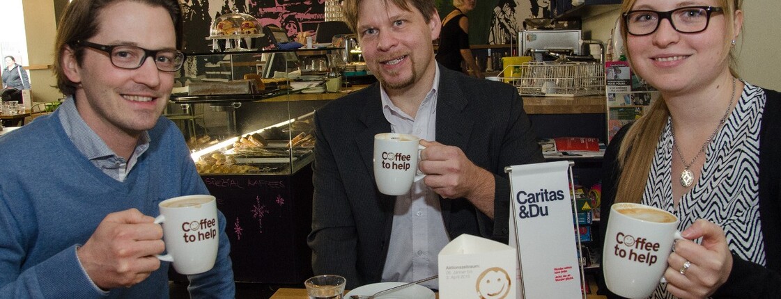 Drei Personen sitzen im Café Emmi und genießen ihren Kaffee.