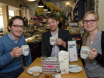 Drei Personen sitzen im Café Emmi und genießen ihren Kaffee.