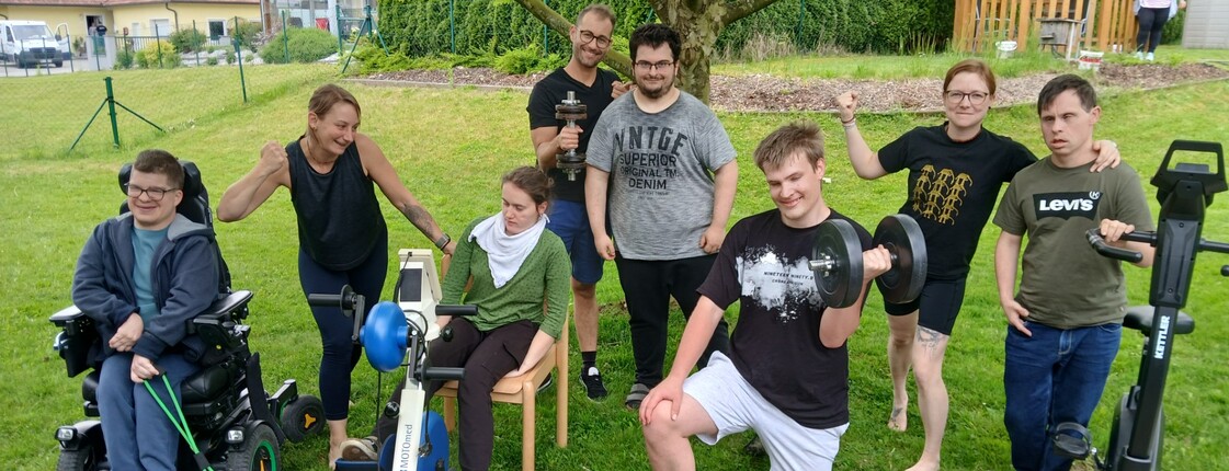 Viele Personen mit Trainingsgeräten im Garten