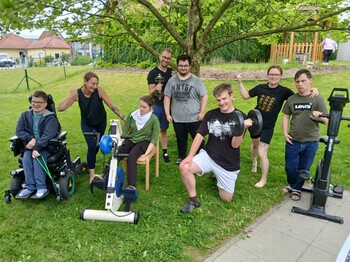 Viele Personen mit Trainingsgeräten im Garten