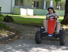Mädchen fährt mit einem roten Go Kart