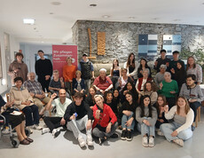 Gruppenfoto von HLW- und Erasmus-Schülerinnen mit Bewohnerinnen im Haus Martha vor Banner „Wir pflegen Zusammenhalt.“