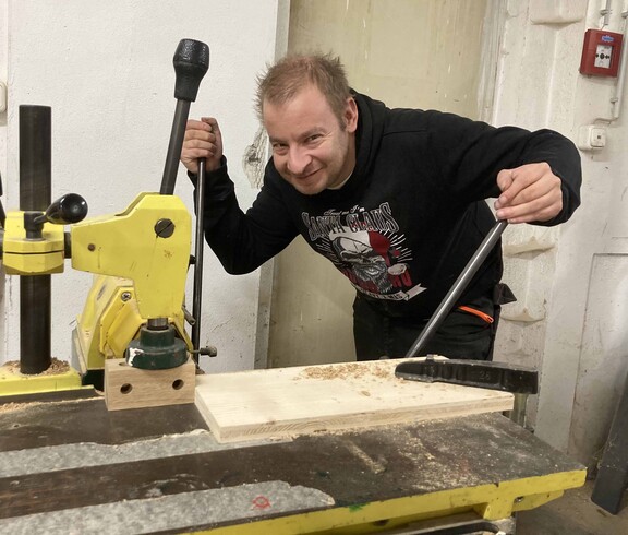 Mann arbeitet an einer Holzbearbeitungsmaschine