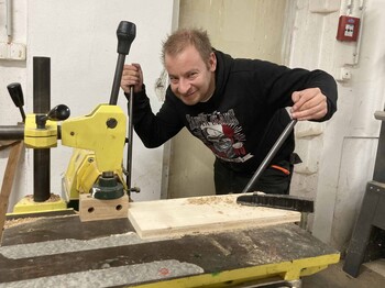 Mann arbeitet an einer Holzbearbeitungsmaschine
