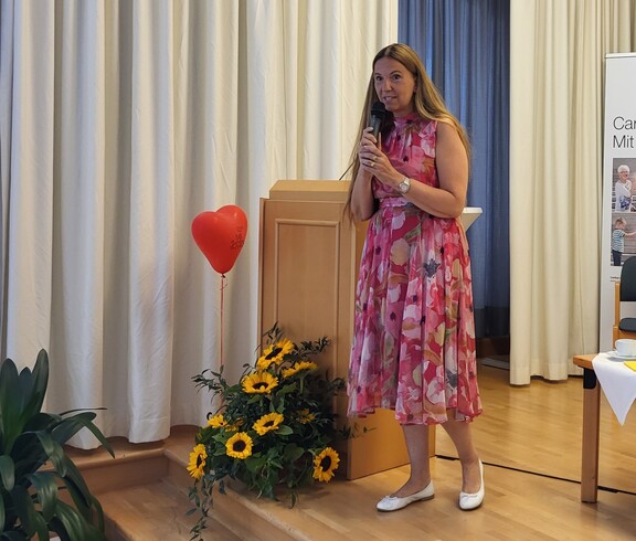 Frau im roten Kleid spricht in ein Mikrofon