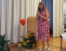Frau im roten Kleid spricht in ein Mikrofon