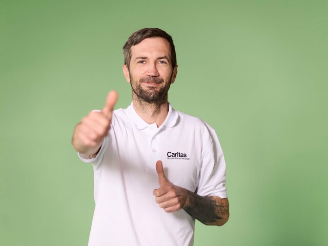 Schüler, der das Daumenhochzeichen in der Kamera hält, grüner Hintergrund