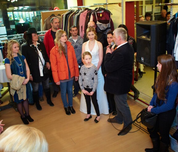 Ein Mann mit Mikrofon unterhält sich mit den Models.