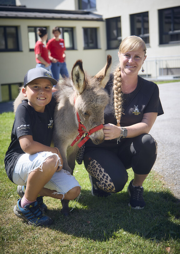 Eine Frau mit Tochter und einem Esel