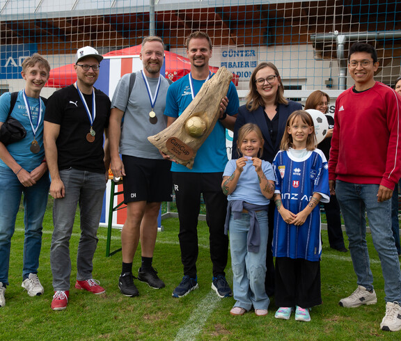 Mannschaftsfoto mit 8 Personen und dem Pokal