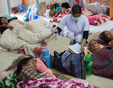 Medizinische Versorgung in Nepal: Menschen liegen in Decken gehüllt am Boden.