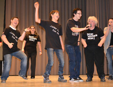 Menschen mit Behinderung tanzen und singen auf einer Bühne. 