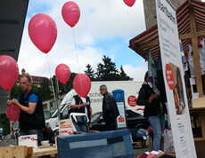 carla stellt in der feldkircher Innenstadt wieder in Stand gesetzte möbel aus. An den Möbel, unter anderem Sessel und Holztische, wurden einige rote Luftballons befestigt. 
