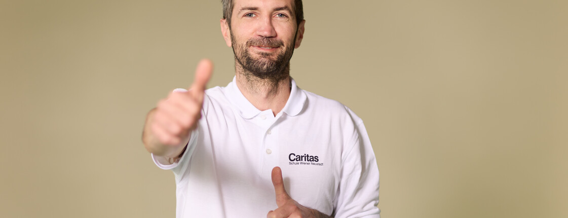 ein Mann, der Daumen hoch zeigt und schmunzelt