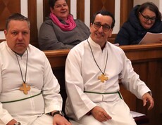 Vier Personen im Chorgestühl einer Kirche
