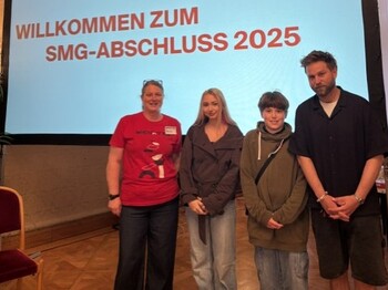 Vier Personen stehen vor einer Präsentationsfläche der WienXtra-Abschlussveranstaltung 2025. Im Hintergrund ist der Veranstaltungstitel sichtbar.