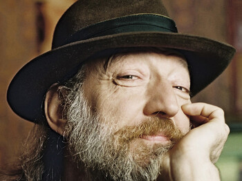 Ein Porträt eines Herrn mit langem Bart. Er trägt einen Hut aus Stoff.