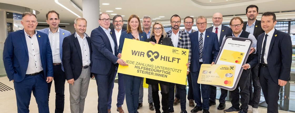 Vertreter*innen von Raiffeisen und Caritas Steiermark bei der Checkübergabe des "Wir hilft." Fonds