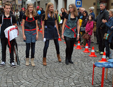 Drei junge Erwachsene und ein junger Erwachsener präsentieren am carla Reuse Day modische Kleidung den ihnen umringenden Personen. Alle vier haben blonde Haare. 