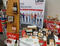 Eine breite Produktpalette der Caritas auf einem Messestand 