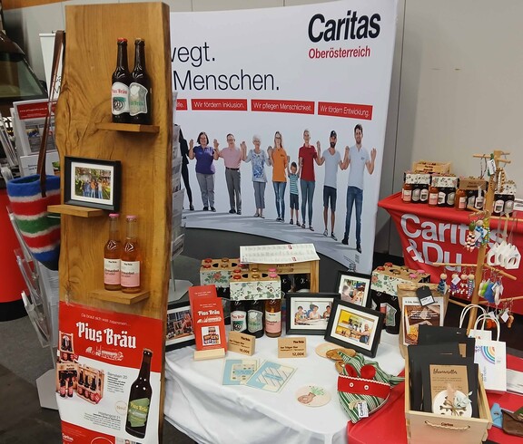 Eine breite Produktpalette der Caritas auf einem Messestand 