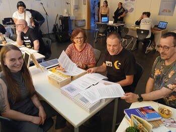 Vier Personen mit Unterlagen an einem Tisch 