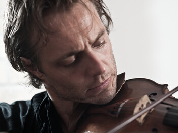 Ein junger Herr spielt auf einer Geige.
