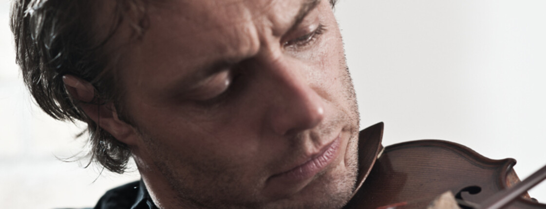 Ein junger Herr spielt auf einer Geige.