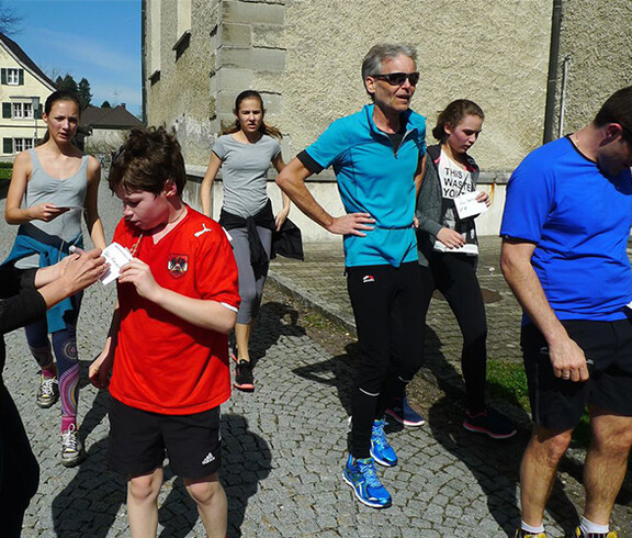 Menschen beim Stundenlauf im Freien. 