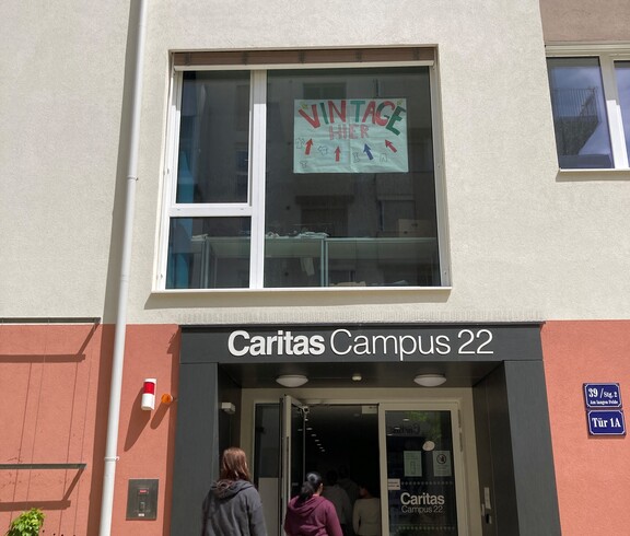 Schulgebäude mit Plakat für Vintage Kleidermarkt