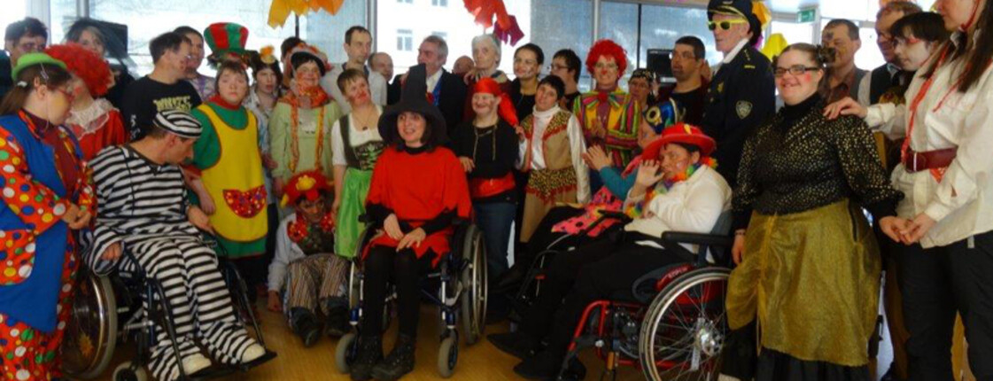 Großes Gruppenbild der Klienten und Mitarbeiter der Werkstätte Bludenz im Fasching. Alle sind verkleidet. 