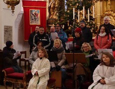 Vier Ministranten und der Chor in einer Kirche