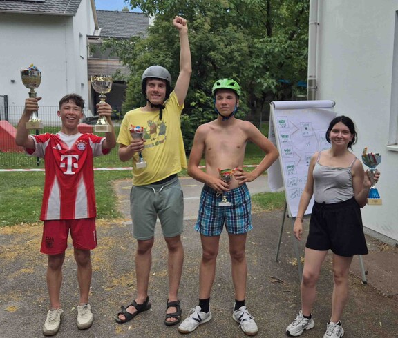 Drei Burschen und ein Mädchen jubeln, nach ihren Gewinnen bem Go-Kart-Rennen