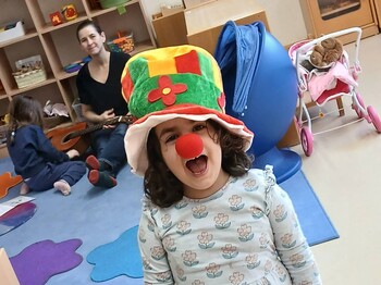 Mädchen mit Clownhut und roter Nase
