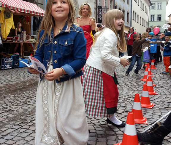 Kinder in Tracht gehen durch die feldkircher Innenstadt anlässlich des carla Reuse Days. 