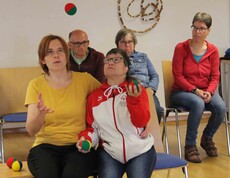 Zwei Personen werfen Bälle in die Luft, einige Zuseher