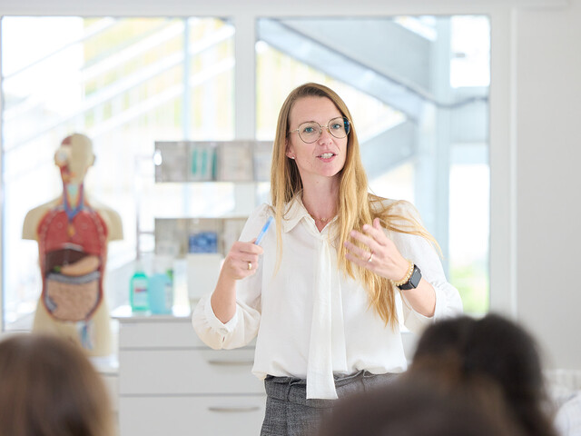 eine Lehrerin, die gerade den Schülern etwas erklärt