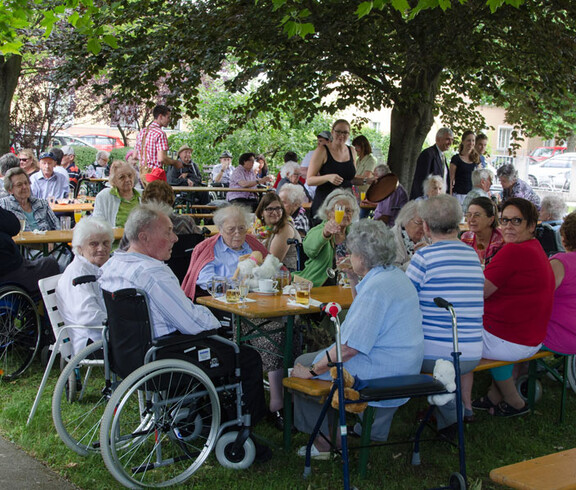Sommerfest Haus St. Elisabeth Gruppenfoto viele Menschen an Tischen