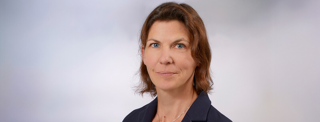 Eine Frau mit Schulterlangen braunen Haaren, einem Sakko und T-Shirt im Portrait