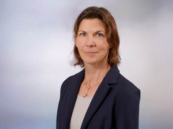 Eine Frau mit Schulterlangen braunen Haaren, einem Sakko und T-Shirt im Portrait