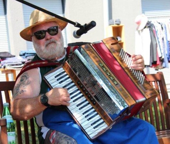 Der Lustige Reini spielt beim Jubiläumsfest des Pflegewohnhauses im Garten auf einem Akkordeon und sorgt für musikalische Unterhaltung.