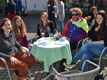 Junge Erwachsene sitzen an einem kleinen runden Tisch beim Generationen Talk. 