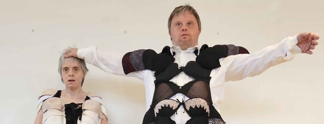 Zwei Schauspieler mit Kostümen aus lauter BHs