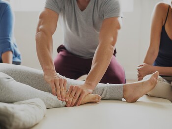 Demonstration einer basale Stimulationan bei einer liegenden Teilnehmerin.