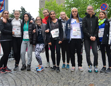 Um die zehn weibliche Jugendliche stehen in der feldkicher Innenstadt bei der Sparkasse zu einem Gruppenfoto zusammen. Sie tragen größtenteils dunkle Kleidung und umarmen sich mitunter gegenseitig. 