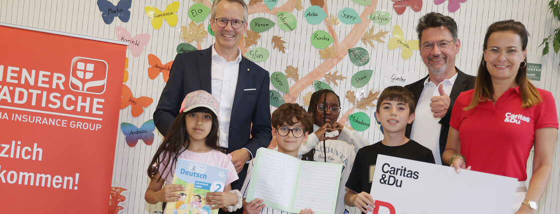 Kinder und Jugendliche im Lerncafé Concordia Klagenfurt zeigen Lernmaterialien, unterstützt von Caritas und Wiener Städtische