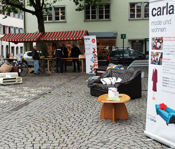 carla stellt wieder Instandgesetzte Möbel in der feldkircher Innenstadt aus. Zwei Roll-ups und eine schwarze Couch stehen am Sparkassenplatz. 