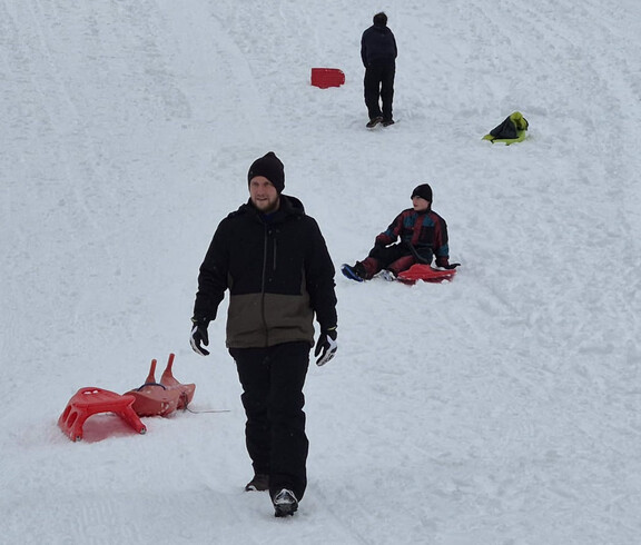 Mehrere Jugendliche mit ihren Rodeln im Schnee